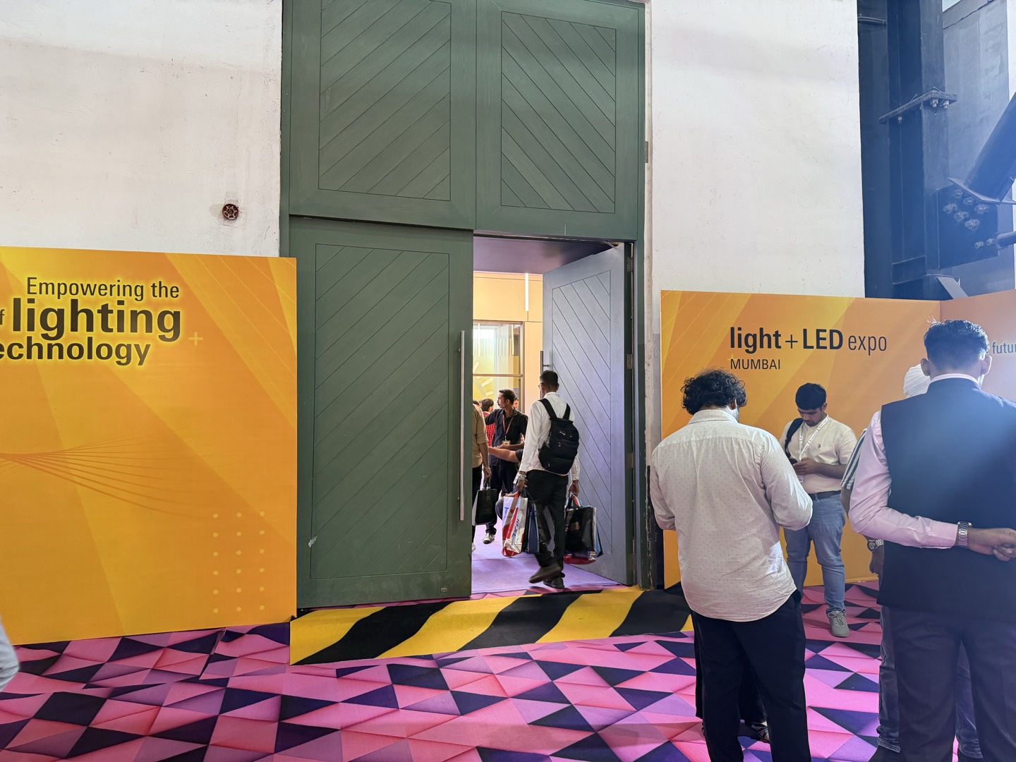 Yellow and black caution carpet marking a cable tray threshold at a live exhibition event