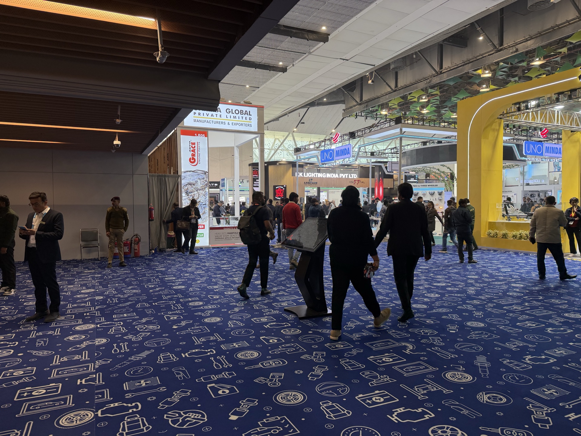 Electronica India — wide exhibition hall entrance with custom blue electronics-icon printed carpet covering the entire open floor at architectural scale