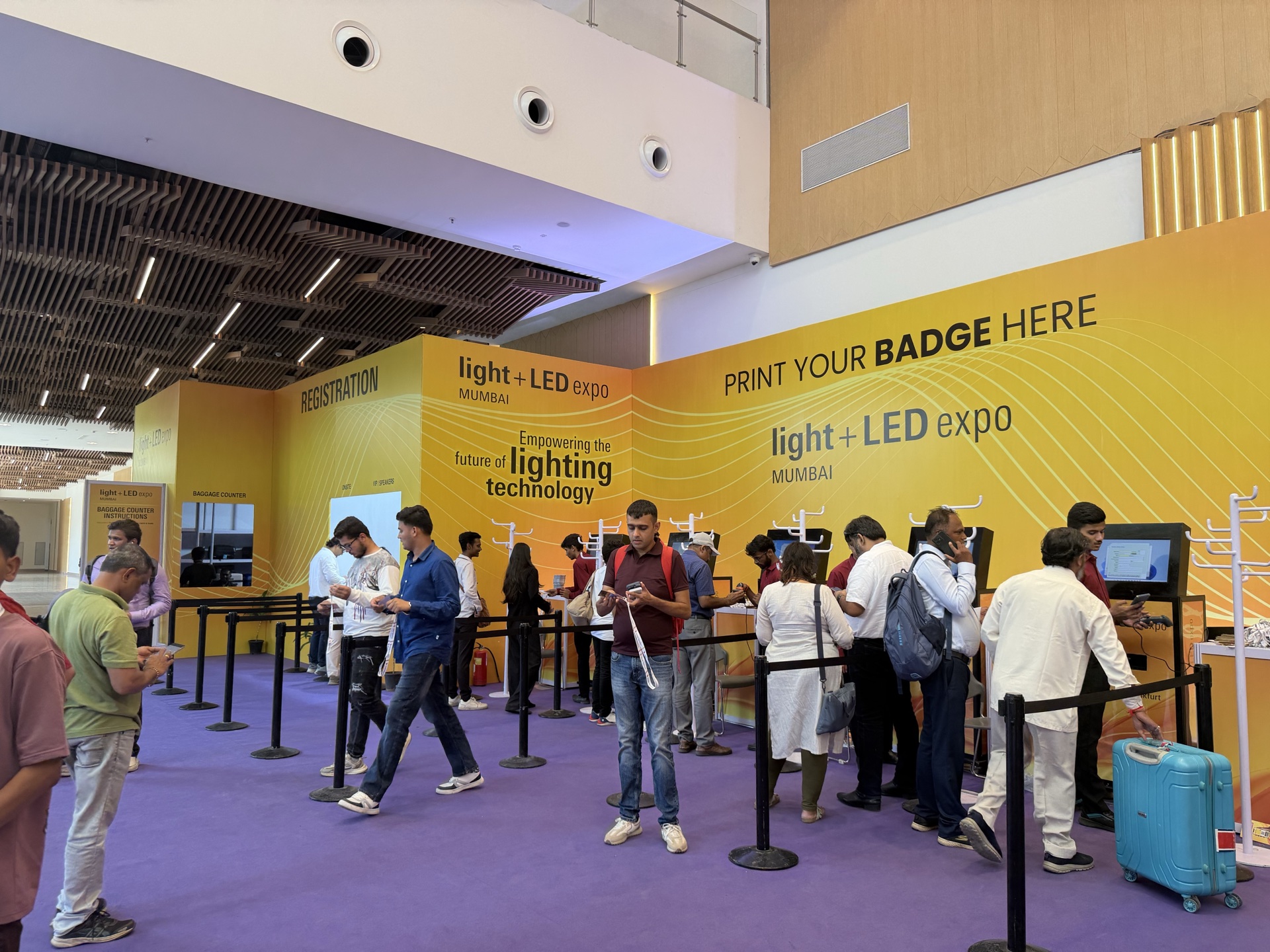 Purple non woven carpet at Light + LED Expo Mumbai — registration desk with attendees on carpet floor